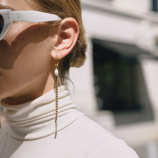 Model wearing 18K gold stainless steel rhinestone pearl tassel earrings