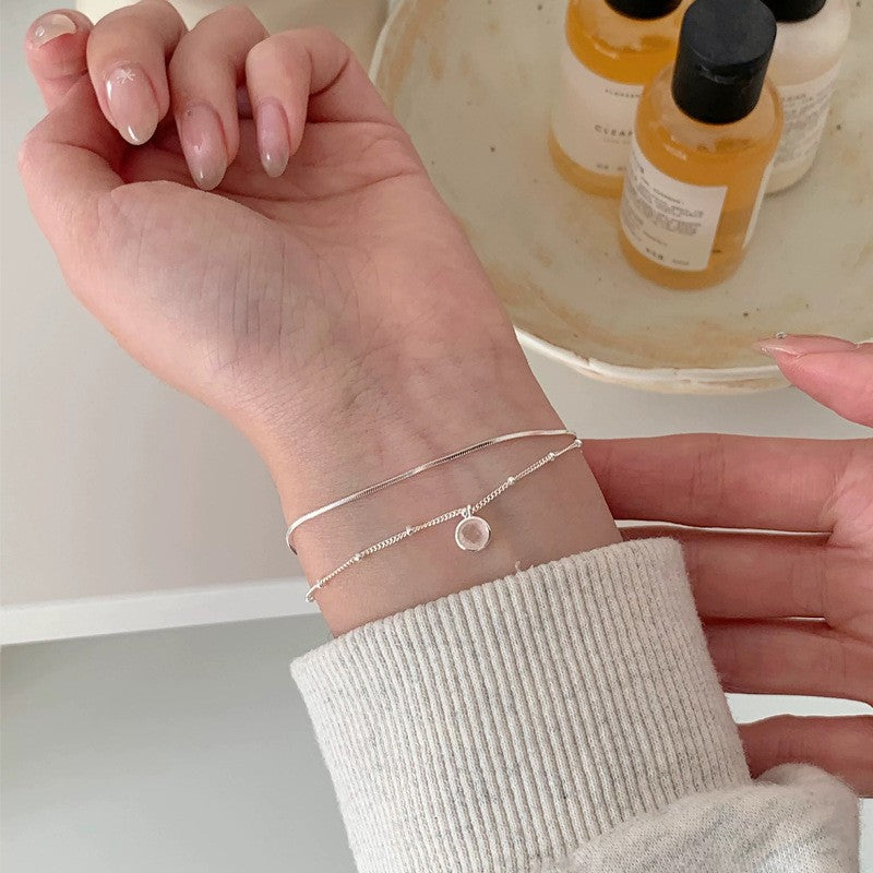 S925 sterling silver layered bracelet with a round pink chalcedony pendant displayed on a wrist