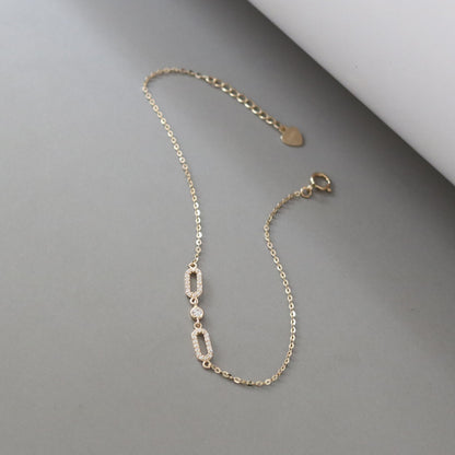 Angled view of S925 sterling silver bracelet with 18K gold plating and oval cubic zirconia links