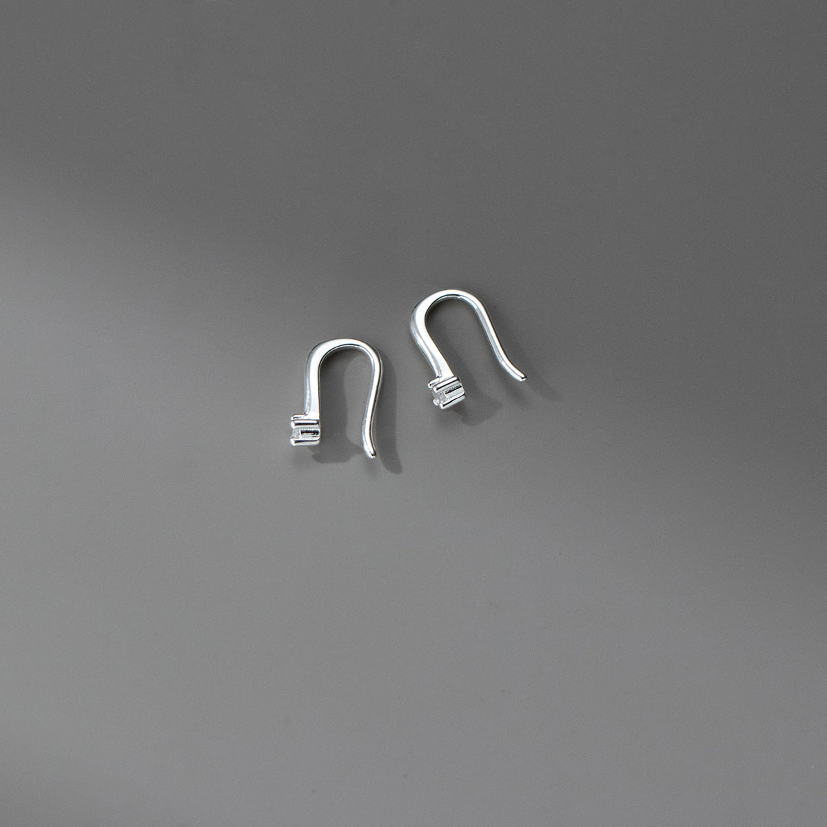 Minimalist sterling silver hook earrings featuring sparkling cubic zirconia