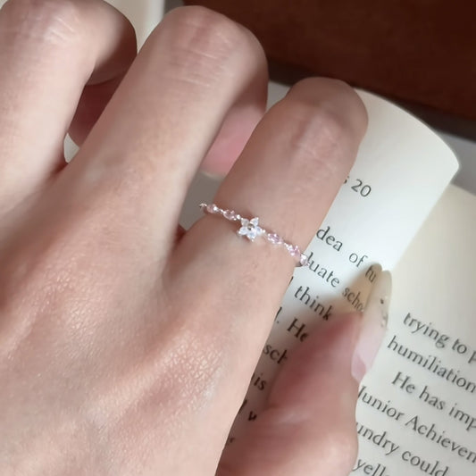 Dainty Sakura Bloom pink zircon ring worn on finger with feminine floral design