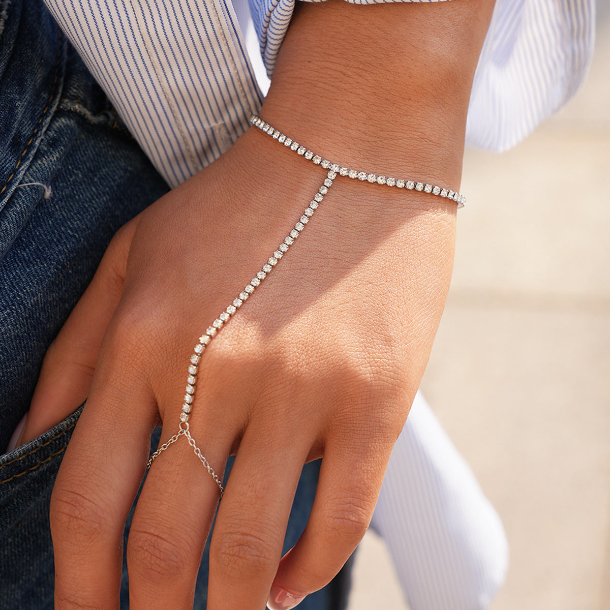 Close view of a silver rhinestone hand chain bracelet worn on the hand