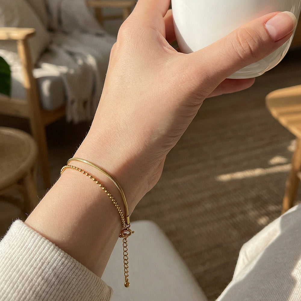 Minimal layered bracelet on wrist snake chain and ball chain stacking style