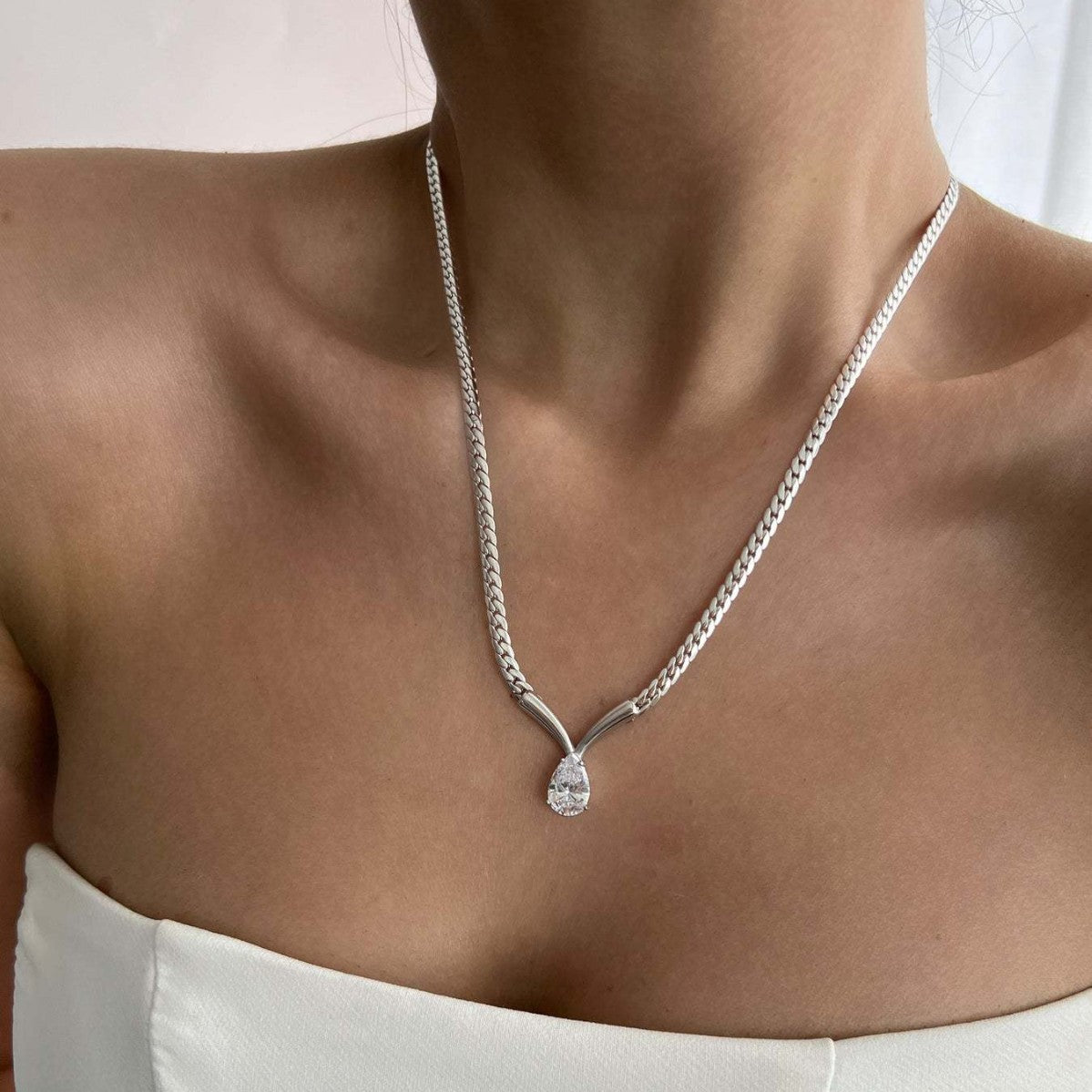 model wearing minimalist snake chain necklace with teardrop zircon pendant