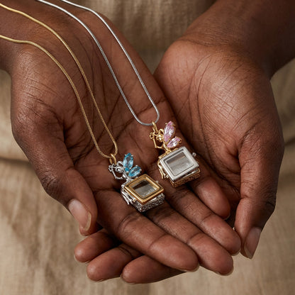 Close up of vintage square box locket pendant necklace with butterfly crystal detail and openable box design