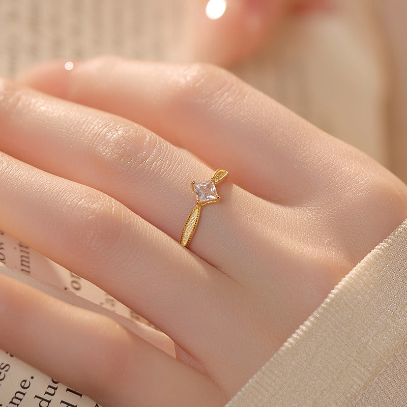 Dainty silver ring with a square CZ, elegantly worn on a finger.