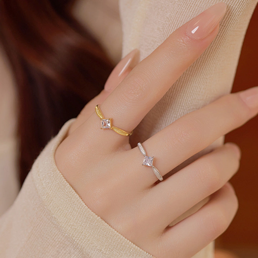 Two adjustable silver rings for women, one gold and one silver, featuring square CZ stones on a hand.