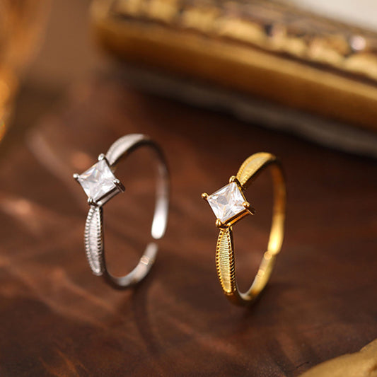 Two 925 wholesale rings, silver and gold, each with a sparkling square CZ stone.