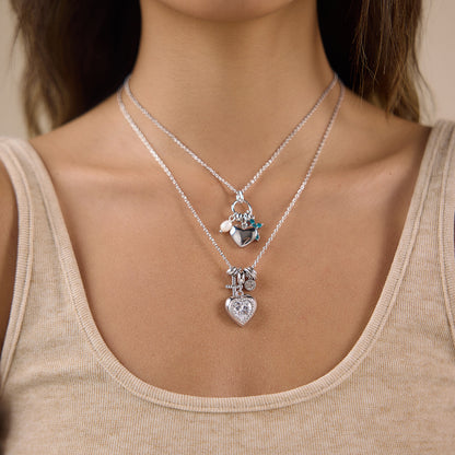 Silver layered charm necklace with heart pendant worn by model
