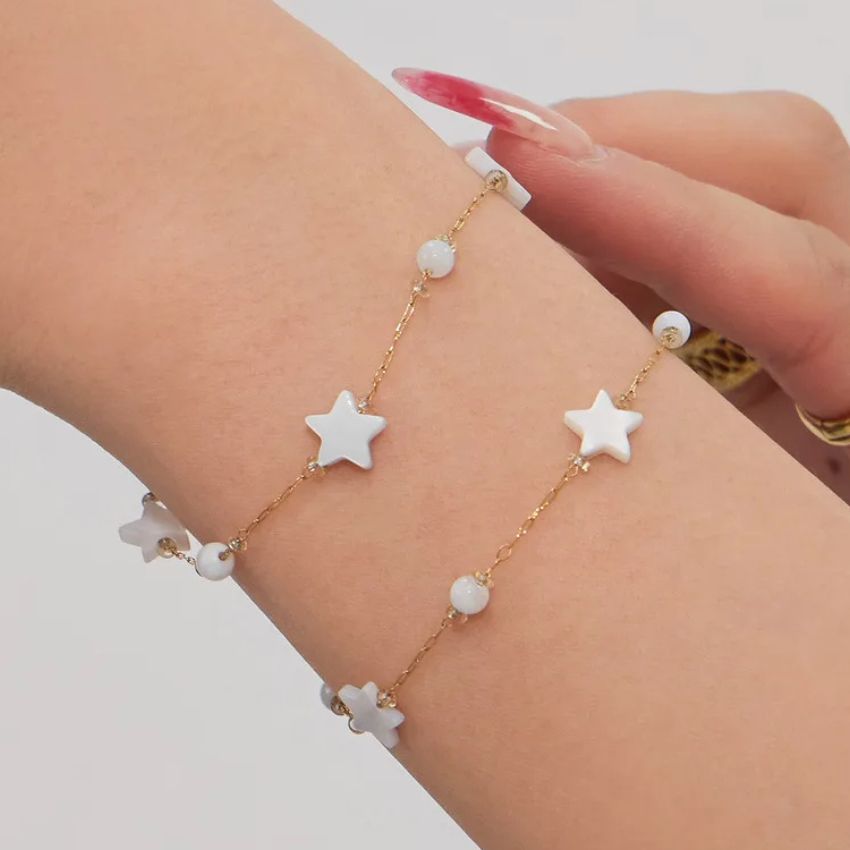 Shell star bracelet close up on wrist gold tone chain with bead accents