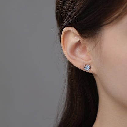 Minimalist moonstone star earrings worn on ear for elegant boutique jewelry style