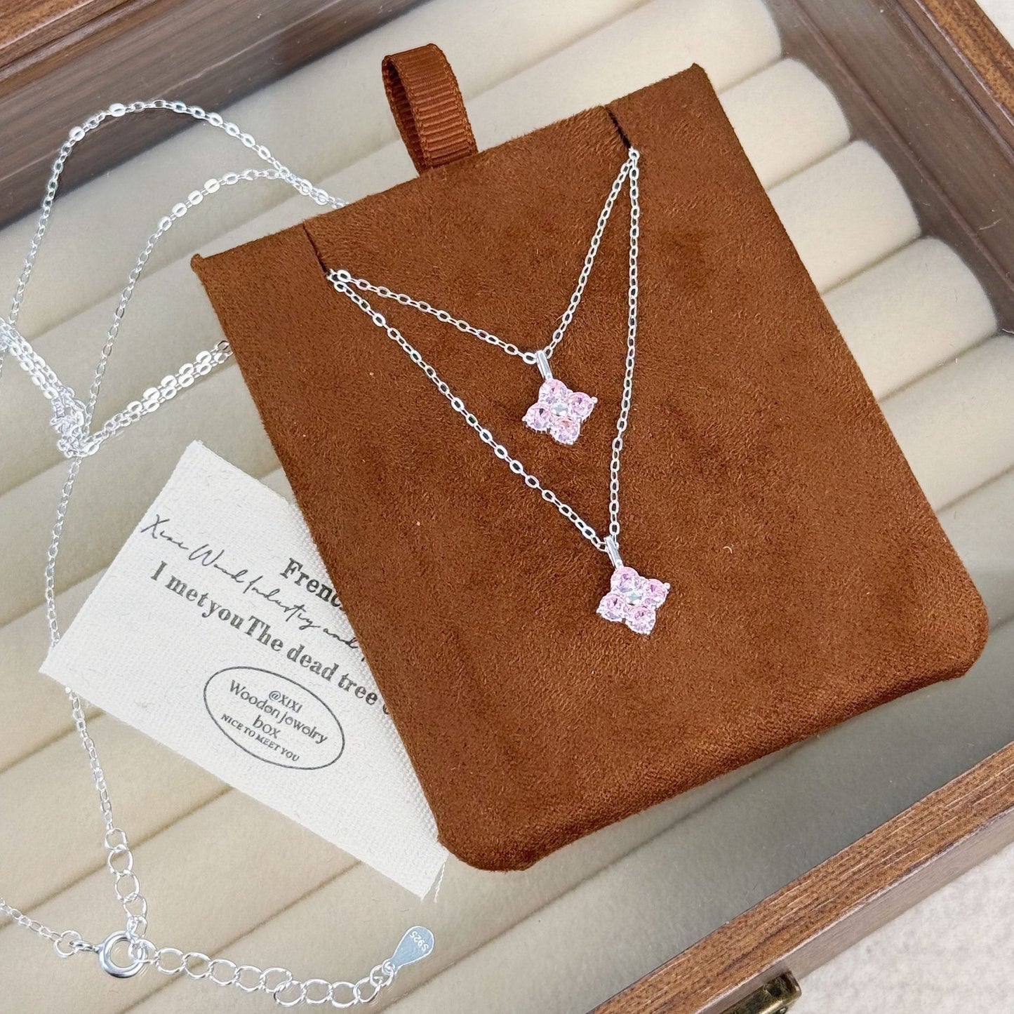 Wholesale 925 sterling silver pink zircon four leaf clover necklaces arranged on a jewelry display.