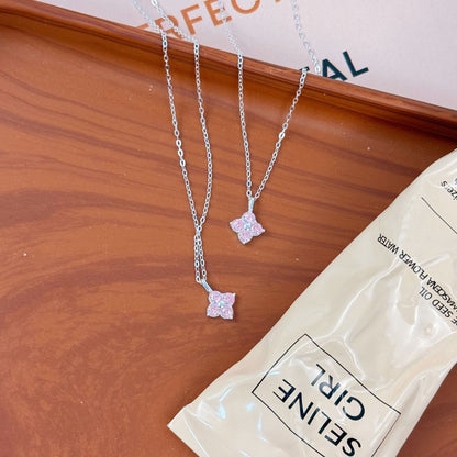 Two wholesale 925 sterling silver pink zircon four leaf clover pendant necklaces on display.