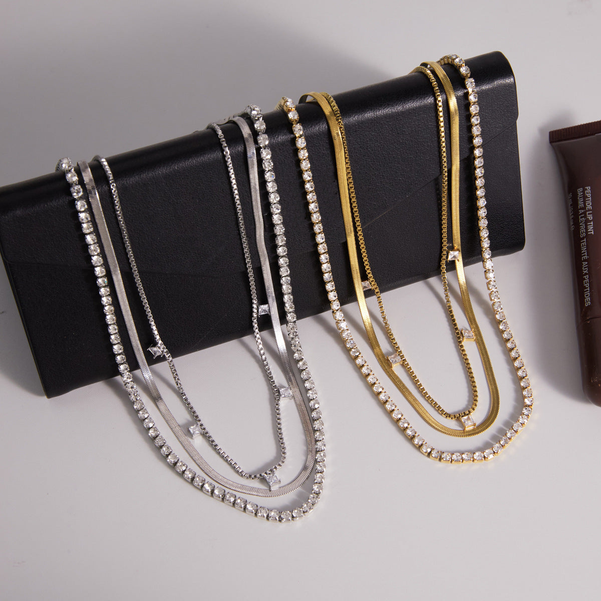 Gold and silver triple layer necklaces with tennis herringbone and square CZ station chains