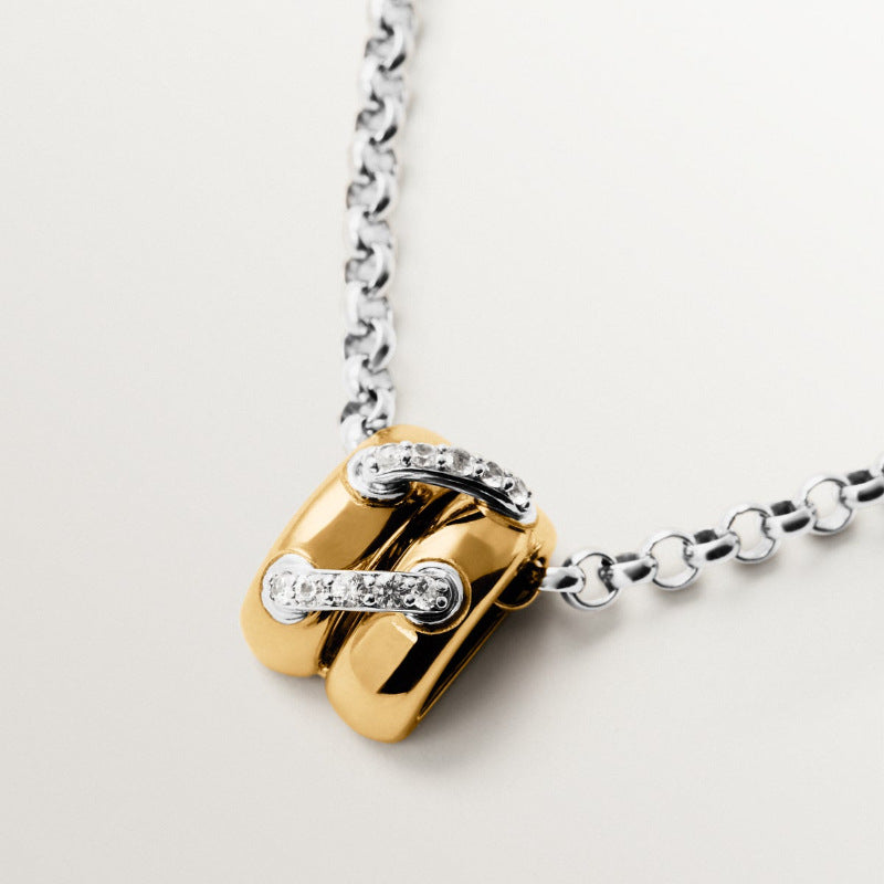 Close up of mixed metal link pendant with pavé zircon accents on silver tone chain