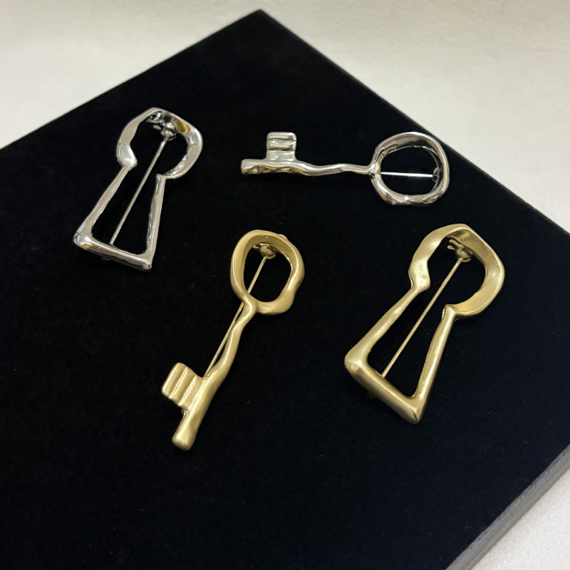 Gold and silver key and keyhole brooch styles displayed together