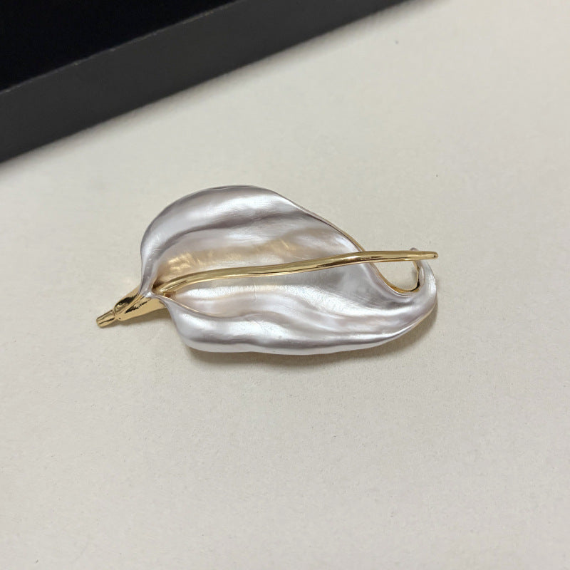 Pearlescent white iris leaf brooch with polished gold tone stem