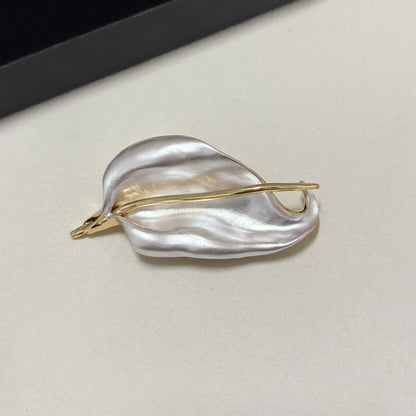Pearlescent white iris leaf brooch with polished gold tone stem