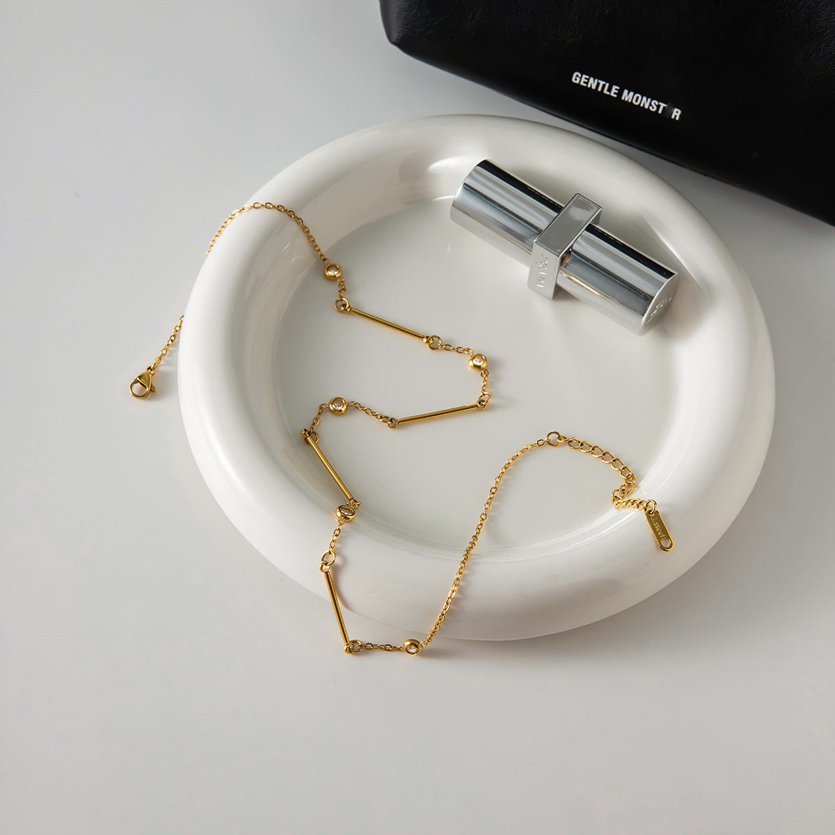 Gold stainless steel bar chain necklace styled on tray