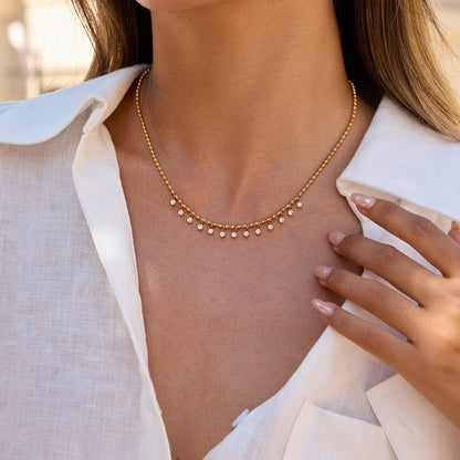 White zircon pendant necklace worn on neckline close up