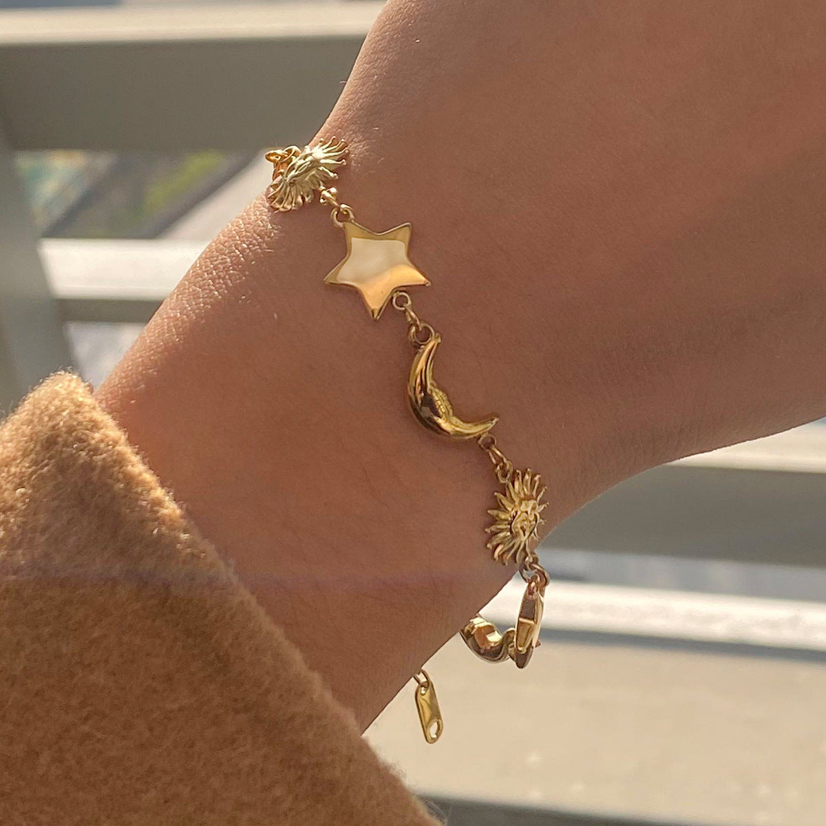 Moon star sun charm bracelet with sizing details made of non tarnish gold stainless steel