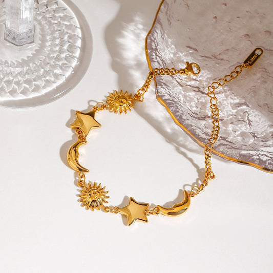 Close-up of gold stainless steel moon star sun bracelet with celestial charms for women