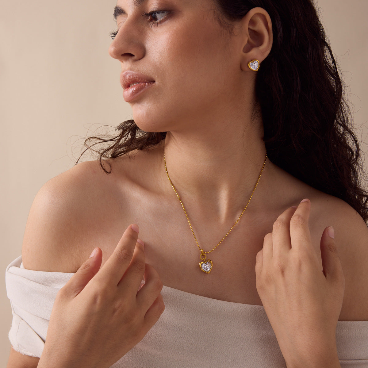 Model wearing gold heart zircon necklace and matching stud earrings
