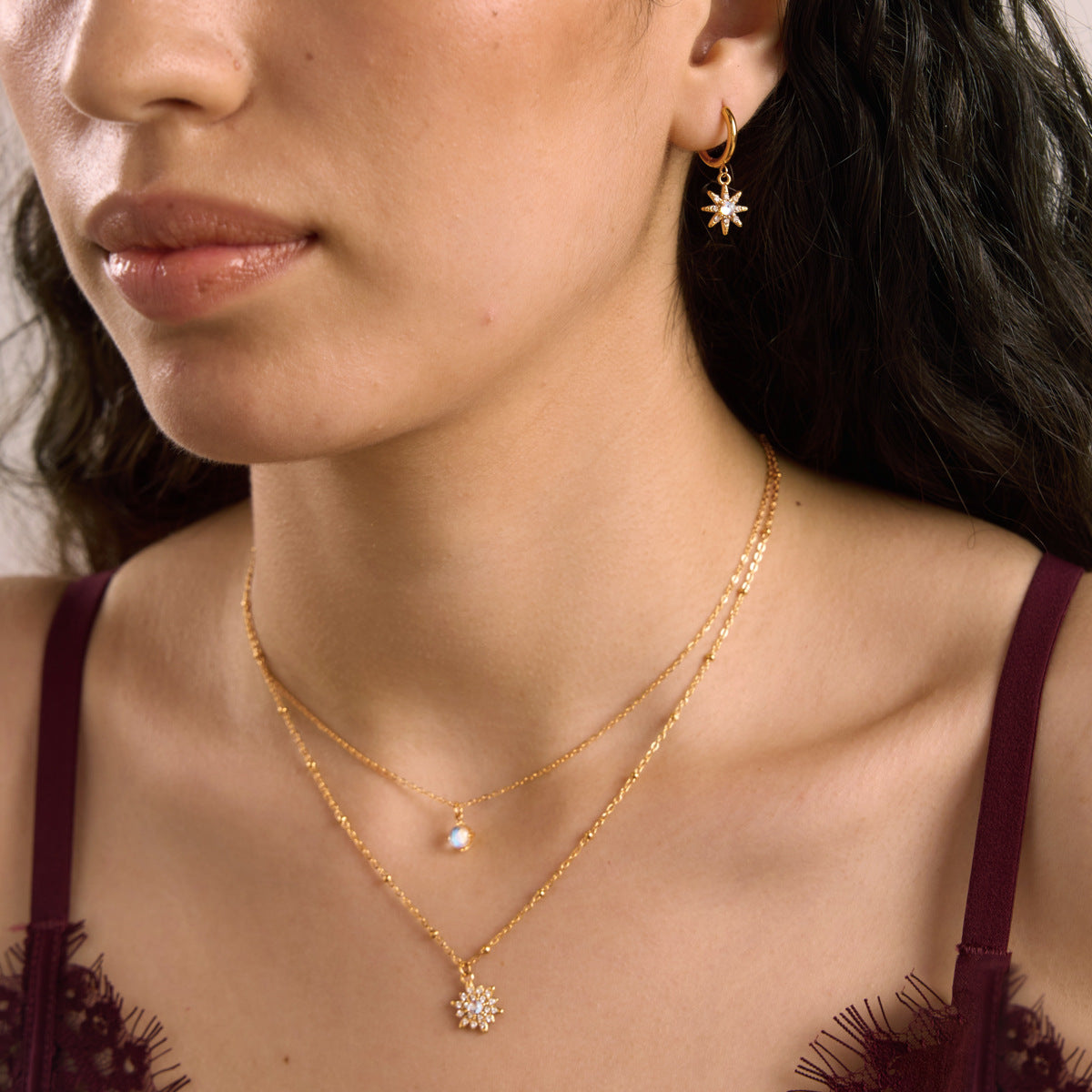 Model wearing a gold moonstone necklace and matching celestial earrings