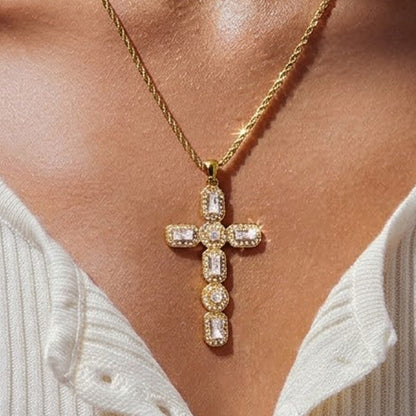 Front view of a gold stainless steel cross pendant set with clear rectangular and round stones