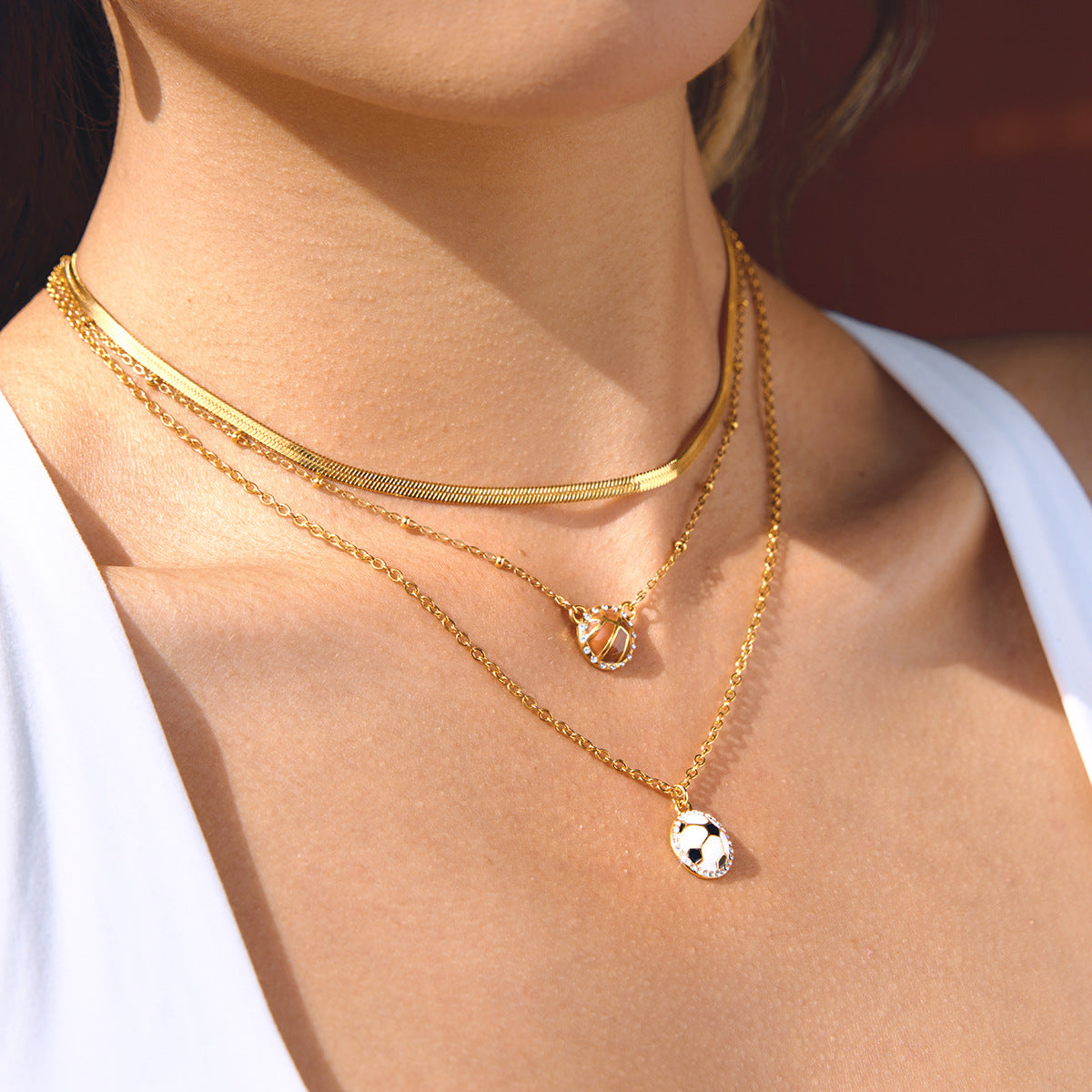 Basketball and soccer pendant necklaces layered with gold tone chains