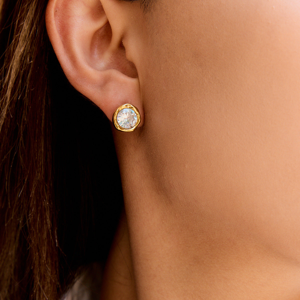 Model wearing gold tone round zircon stainless steel stud earrings