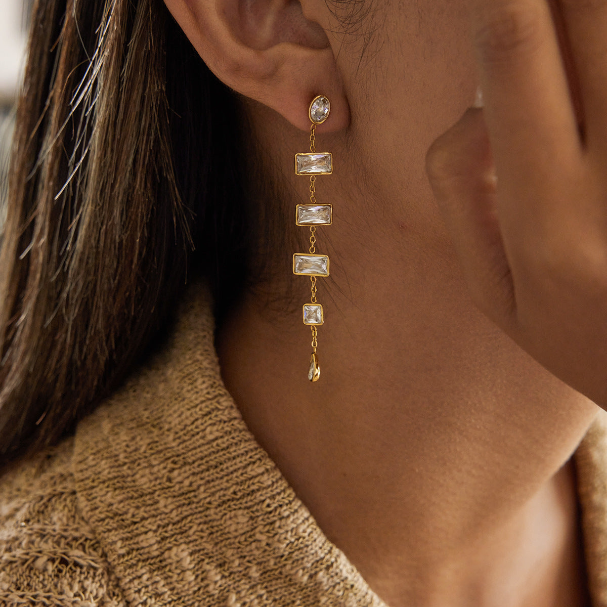 Model wearing long gold zircon tassel earrings close up view