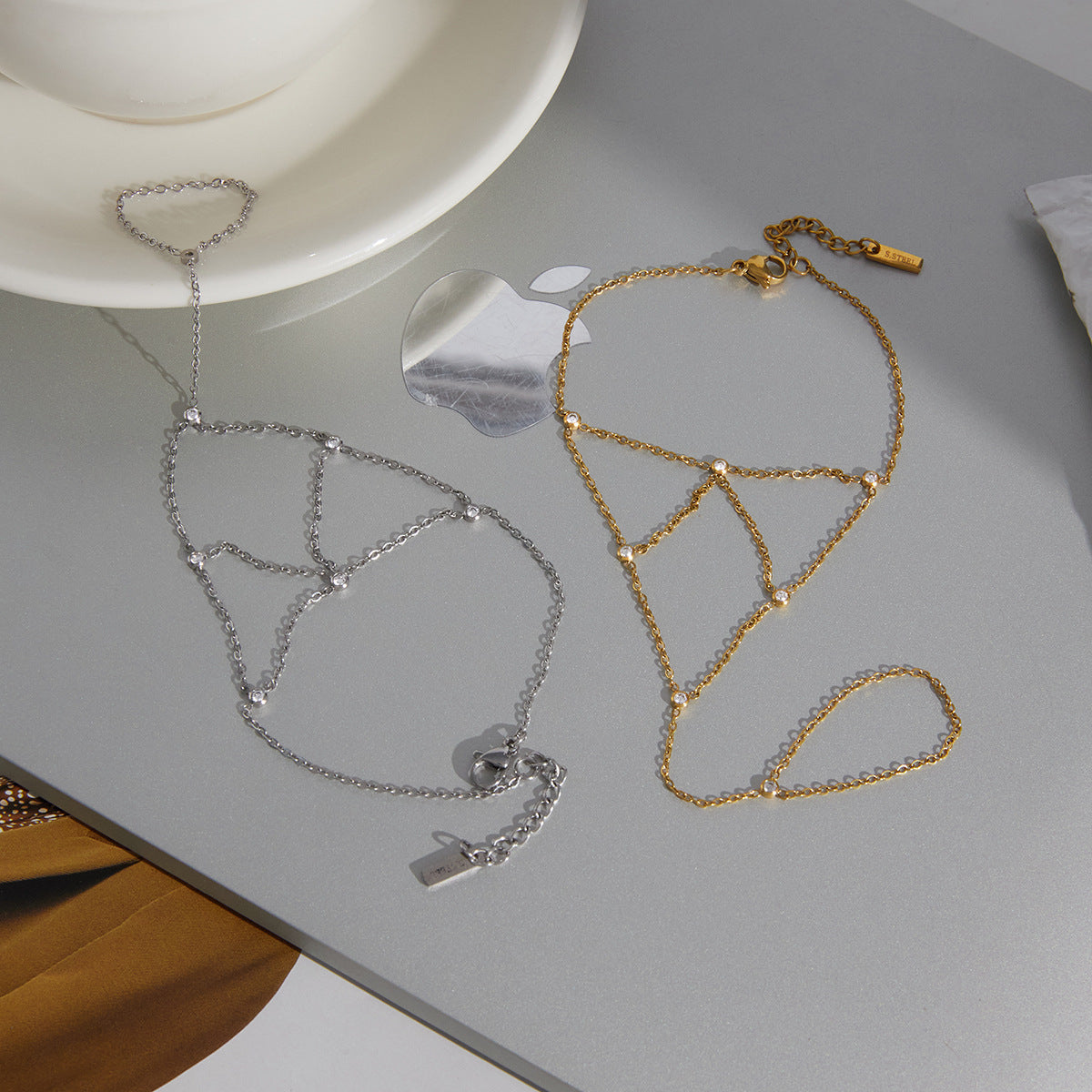 Gold and silver stainless steel zircon finger bracelets displayed on surface