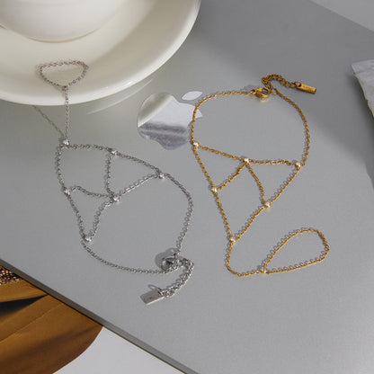 Gold and silver stainless steel zircon finger bracelets displayed on surface