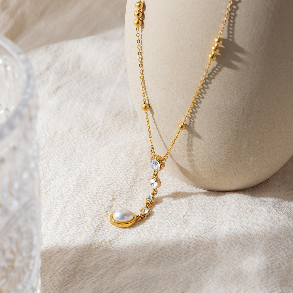 Gold stainless steel zircon pearl Y necklace flat lay display