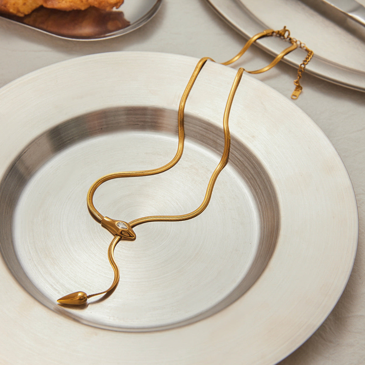 18K gold stainless steel zircon snake Y necklace styled on metallic plate