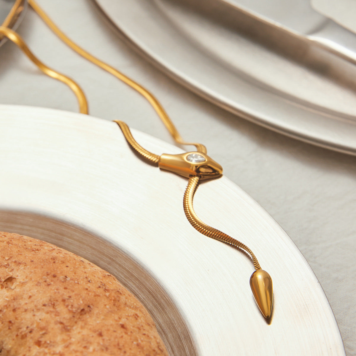 Close up of zircon slider detail on gold snake Y necklace